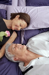 Mature couple in love lying on bed looking at each other - CHAF000295