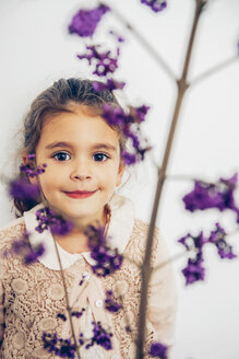 Portrait of smiling girl behind blossom - CHAF000317