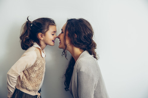 Glückliche Mutter und Tochter reiben sich die Nasen, lizenzfreies Stockfoto