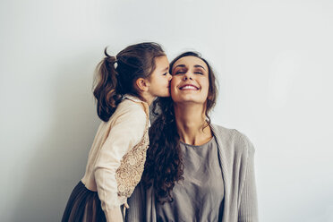 Daughter kissing smiling mother's cheek - CHAF000320