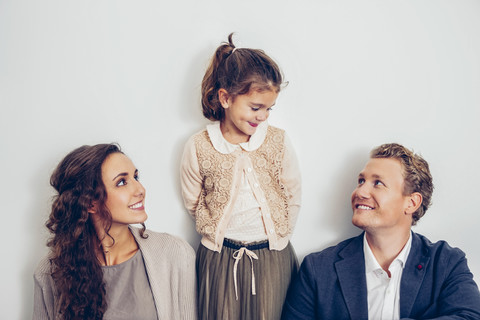 Lächelndes Mädchen, das seinen Vater anschaut, mit seiner Mutter an seiner Seite, lizenzfreies Stockfoto