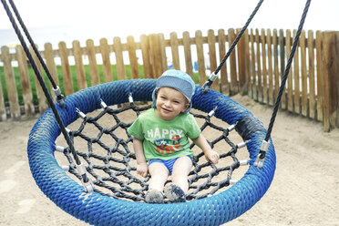 Spain, Majorca, Alcudia, toddler sitting on a swing - GDF000763