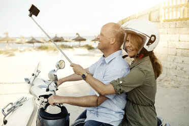 Spanien, Mallorca, Alcudia, Paar mit Selfie-Stick auf Motorroller - GDF000786