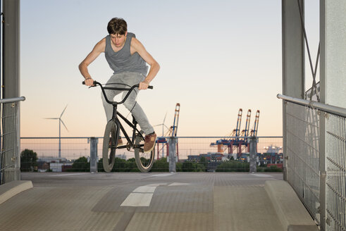 Deutschland, Hamburg, Jugendlicher springt mit BMX-Rad auf eine Parkdeckrampe - MEMF000811