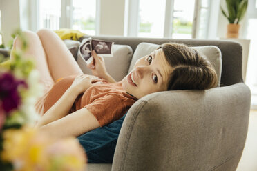 Schwangere Frau mit Ultraschalluntersuchung entspannt auf der Couch - MFF001810