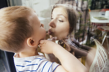 Mother and son kissing through a window - MFF001794