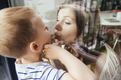 Mutter und Sohn küssen sich durch ein Fenster - MFF001794