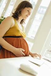 Schwangere Frau bei der Arbeit in ihrem Heimbüro - MFF001804