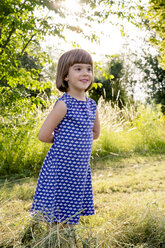 Portrait of little girl standing in hay field - LVF003631