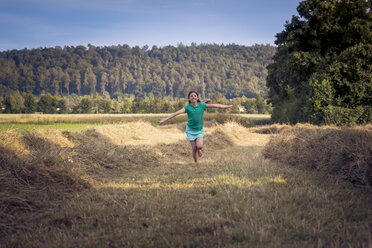 Girl running on a hay field - LVF003632
