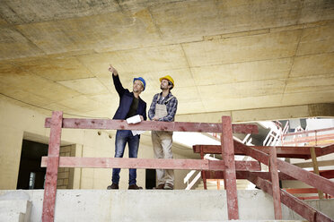 Bauarbeiter und Architekt im Gespräch auf der Baustelle - FMKF001607