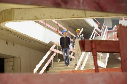 Construction worker and architect on construction site - FMKF001609