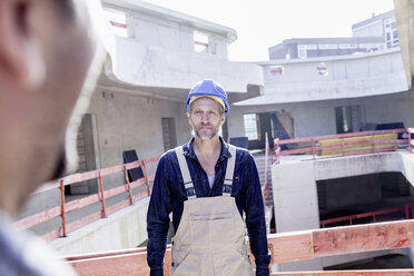 Confident man with hard hat on construction site - FMKF001674
