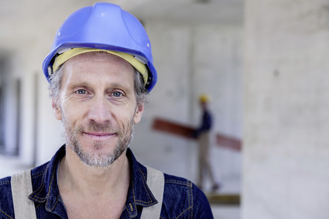Lächelnder Arbeiter auf einer Baustelle, lizenzfreies Stockfoto