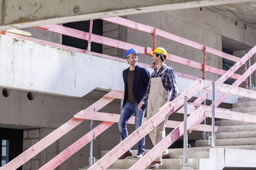 Bauarbeiter und Architekt auf der Baustelle gehen die Treppe hinunter - FMKF001711