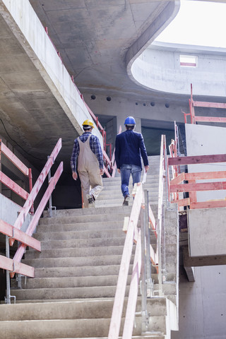 Construction worker and architect on construction site walking upstairs stock photo