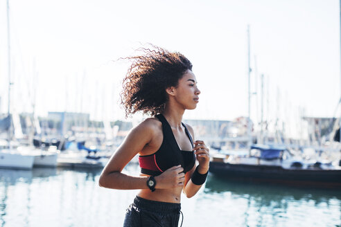 Spain, Barcelona, jogging young woman in front of the harbour - EBSF000727