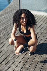 Young jogger crouching on a terrace having a rest - EBSF000742