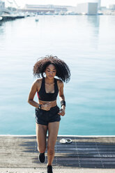 Spain, Barcelona, jogging young woman in front of the harbour - EBSF000744