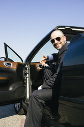 Geschäftsmann mit Sonnenbrille lächelnd in einem Cabrio sitzend - ABZF000201