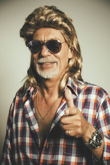 Portrait of smiling man wearing sunglasses and blond wig showing thumbs up - MFF001675