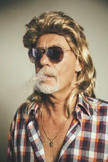 Porträt eines rauchenden Mannes mit Sonnenbrille und blonder Perücke - MFF001676