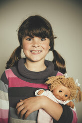 Porträt eines grinsenden Mädchens mit Puppe - MFF001678