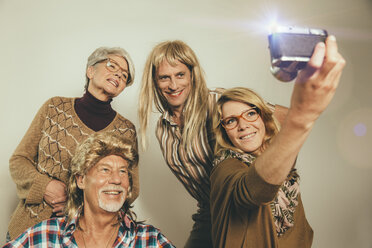 Eine Familie, gekleidet wie in den Achtzigern, macht ein Selfie - MFF001683