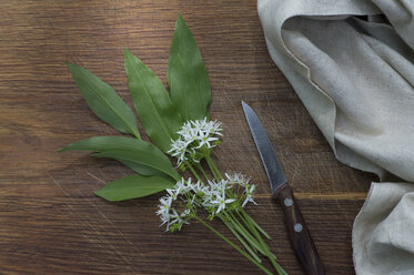 Frischer Bärlauch, Blüten und Küchenmesser auf Holz - CRF002698