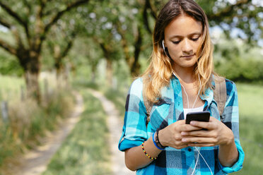 Teenager-Mädchen mit Smartphone und Kopfhörern - GIOF000070