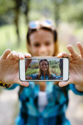 Lächelndes Teenager-Mädchen macht ein Selfie mit Smartphone - GIOF000072