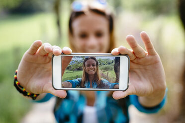 Lächelndes Teenager-Mädchen macht ein Selfie mit Smartphone - GIOF000073