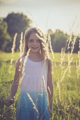 Little girl standing on a meadow at backlight - SARF002024