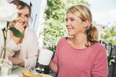 Zwei Frauen sitzen am Frühstückstisch auf dem Balkon - MFF001704