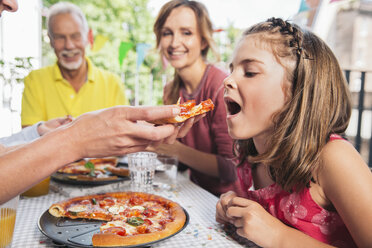 Mädchen wird auf einer Familienfeier mit selbstgemachter Pizza gefüttert - MFF001710