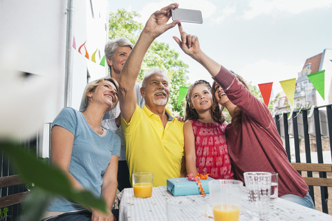 Drei Generationen Familie machen ein Selfie auf dem Balkon, lizenzfreies Stockfoto