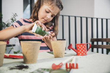 Little girl gardening with seeds and soil on balcony - MFF001782