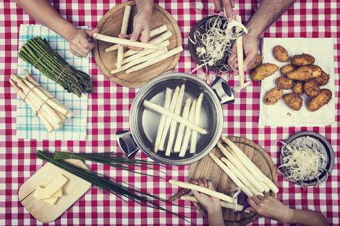 Three people peeling asparagus - MIDF000506