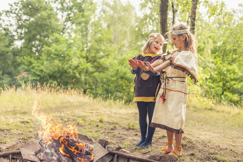 Deutschland, Sachsen, Indianer und Cowboytruppe, Mädchen stehen am Feuer und wärmen sich die Hände - MJF001651