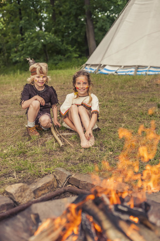 Deutschland, Sachsen, Indianer und Cowboyparty, Kinder sitzen am Lagerfeuer, lizenzfreies Stockfoto