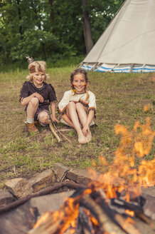 Deutschland, Sachsen, Indianer und Cowboyparty, Kinder sitzen am Lagerfeuer - MJF001652