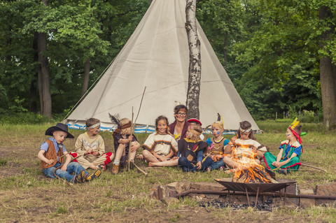 Deutschland, Sachsen, Indianer und Cowboyparty, Kinder sitzen am Lagerfeuer, lizenzfreies Stockfoto