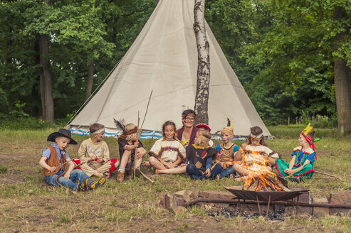 Deutschland, Sachsen, Indianer und Cowboyparty, Kinder sitzen am Lagerfeuer - MJF001653