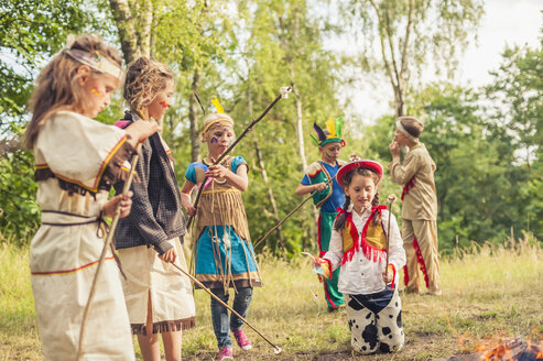 Deutschland, Sachsen, Indianer und Cowboy-Party, Kinder, die Marshmallows auf Stöcken rösten - MJF001676