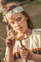 Germany, Saxony, Indians and cowboy party, Girl with roasted marshmallow on stick - MJF001666