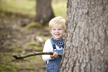 Portrait of smiling little boy with branch - MFRF000234