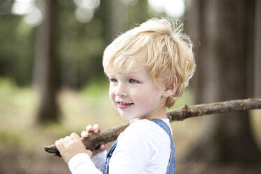 Porträt eines lächelnden kleinen Jungen mit Zweig - MFRF000235