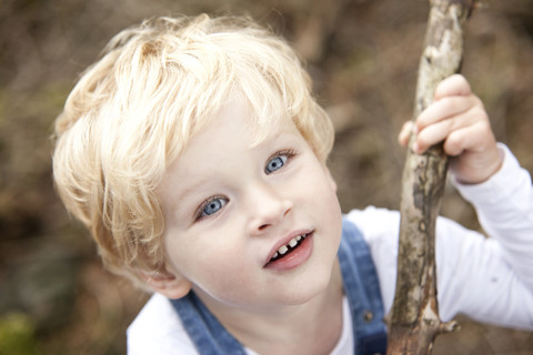 Porträt eines kleinen Jungen mit Zweig, lizenzfreies Stockfoto