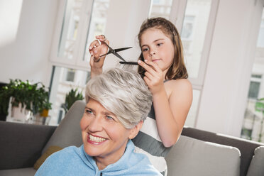 Mädchen schneidet die Haare ihrer Großmutter zu Hause - MFF001687