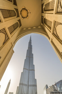 Vereinigte Arabische Emirate, Dubai, Der Burj Khalifa eingerahmt von einem historischen arabischen Bogen im Abendlicht - NKF000266